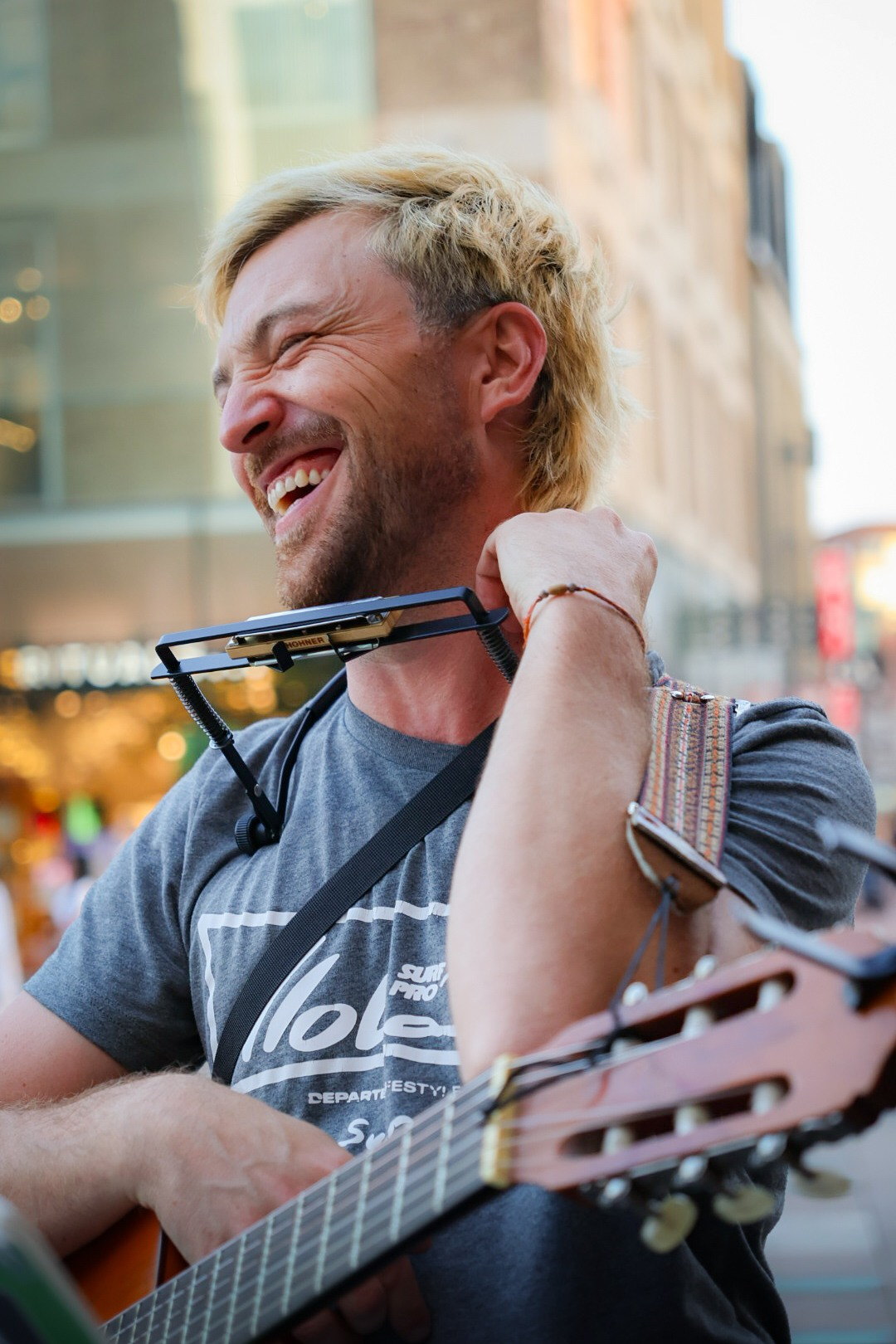 Smiling street musician with a guitar photographed by JP Captivated.