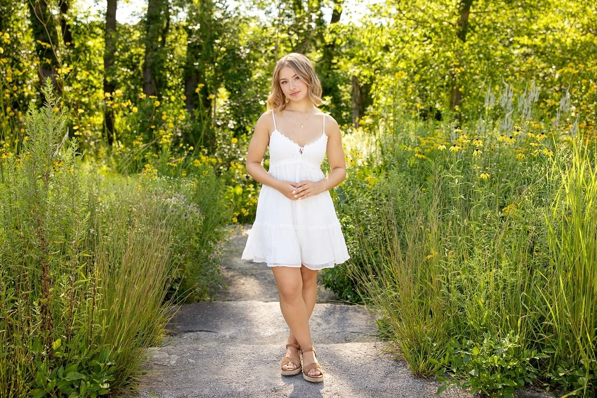 Madalina in a white summer dress in a green park setting