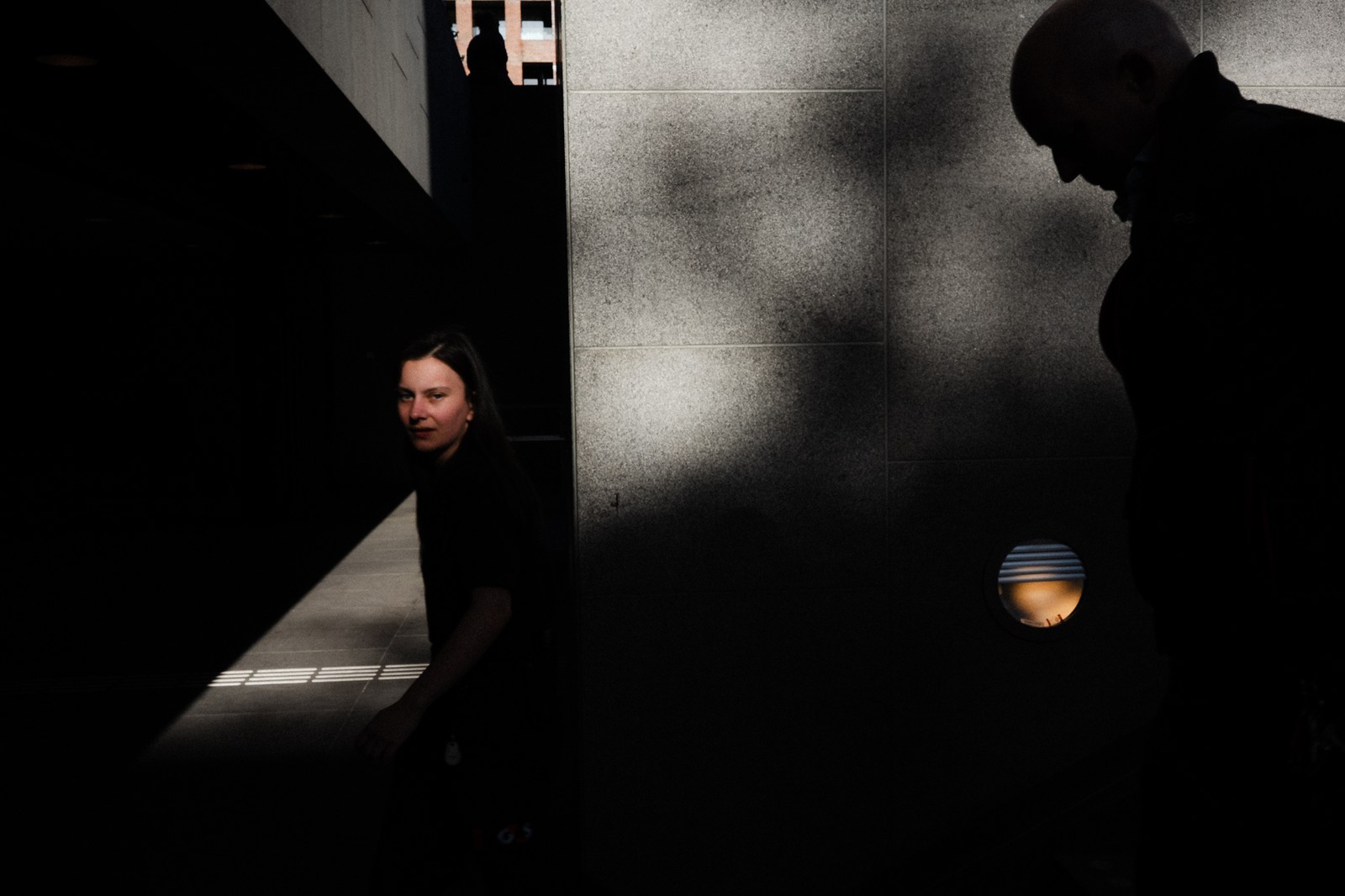 Street photograph by Yahya combining people, architecture, light and shadow